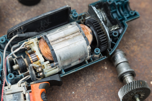 Disassembled  electric drill on  metal rusted background.