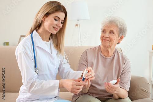 Young nurse examining elder...