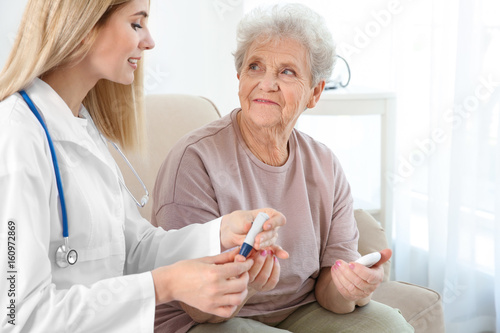 Young nurse examining elder...