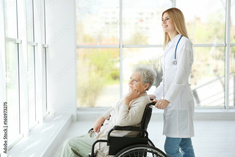 Young nurse and disabled elderly woman in wheelchair at home Young nurse and disabled elderly woman in wheelchair at home