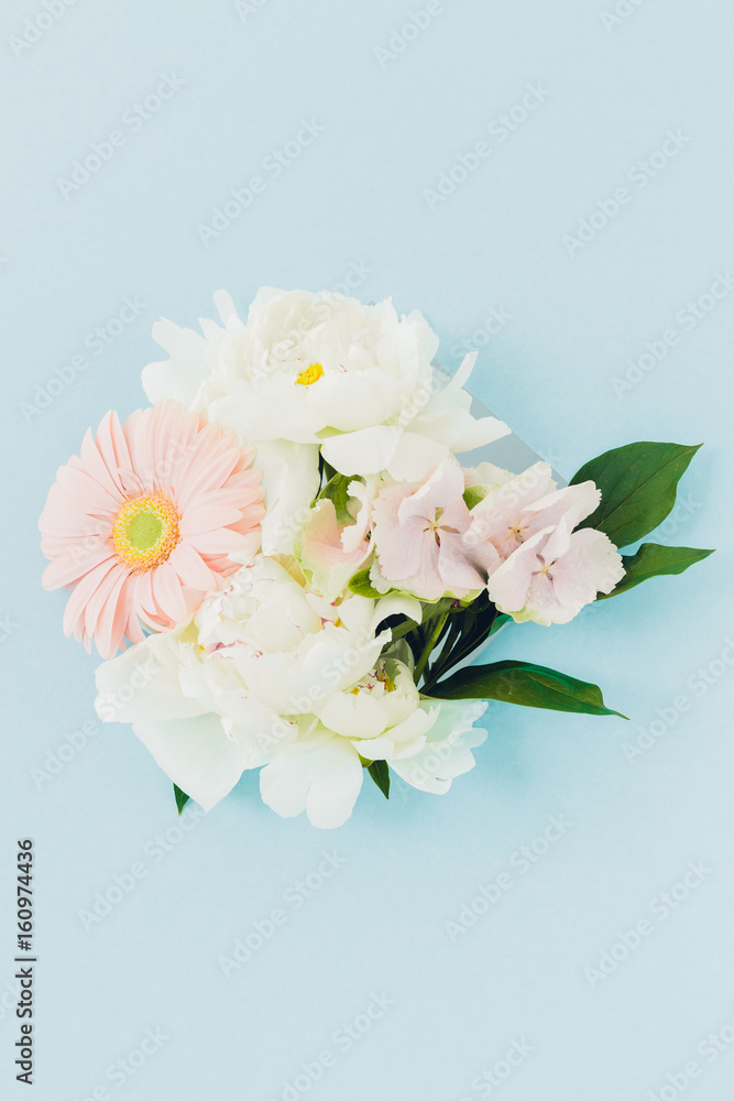 Bouquet of white and blue flowers in frame on blue background Bouquet of white and blue flowers in frame on blue background