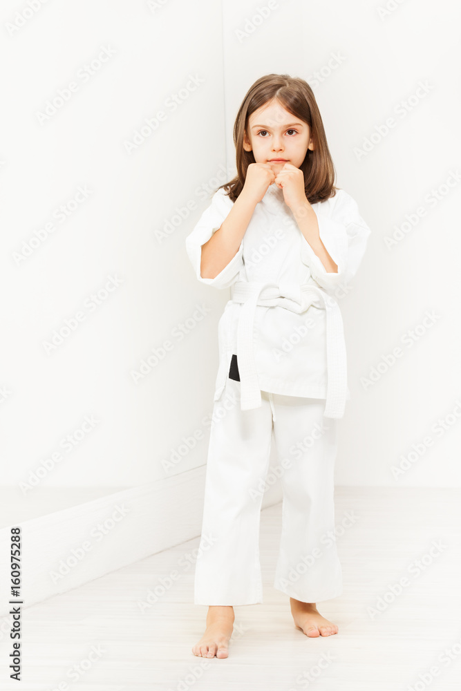 Sporty little girl standing in karate position Sporty little girl standing in karate position