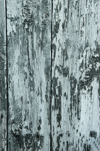 abstract wooden background with cracks on the blue paint, vertical frame.