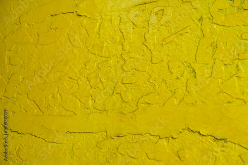 Abstract yellow solid background with cracks in the paint. Texture. A horizontal frame.