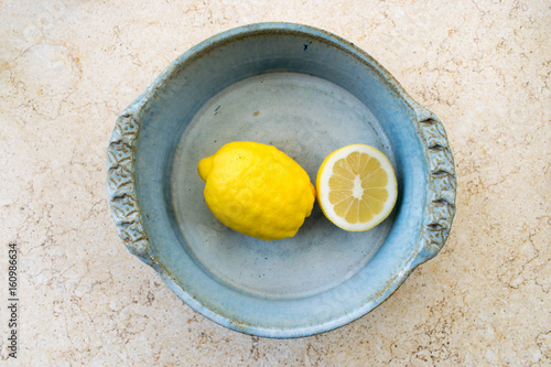 Lemons in a rustic bowl, on a marble background