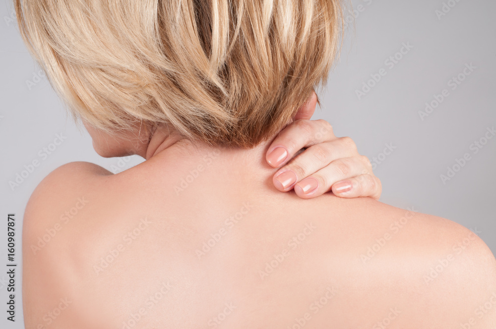 Young woman with neck pain, massaging her shoulder Young woman with neck pain, massaging her shoulder