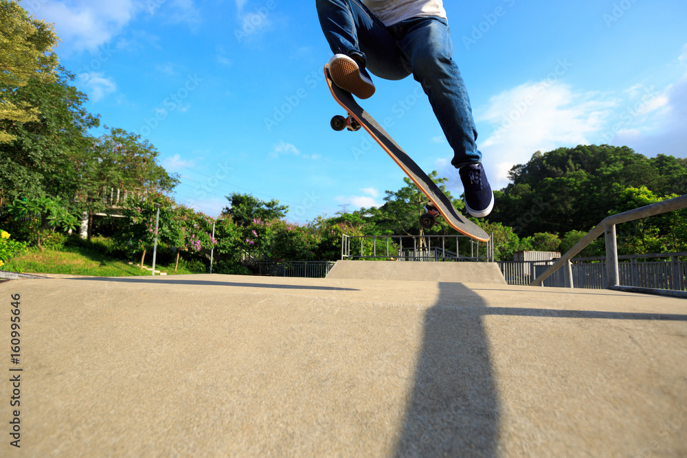 Obraz premium young skateboarder legs skateboarding at skatepark