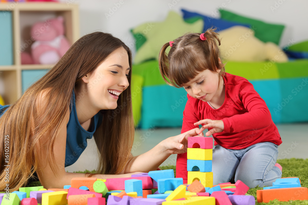 Naklejka premium Mother and daughter playing with construction toys
