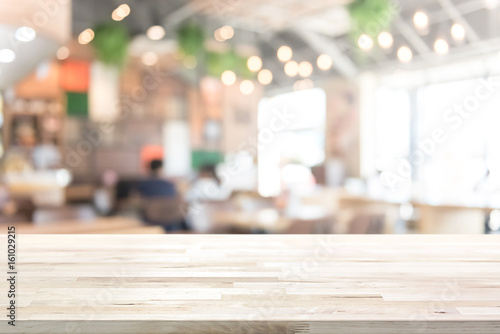 Wood table top on blur restaurant (cafe) interior background