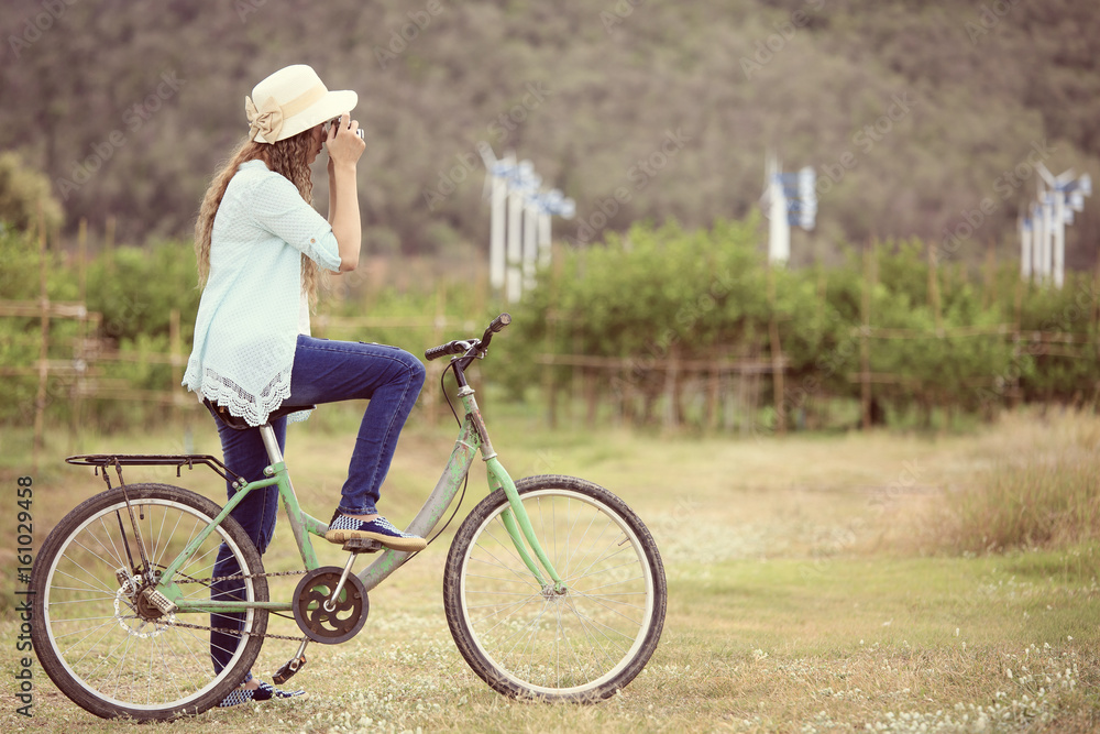 Fototapeta premium Asian woman on bicycle taking photo