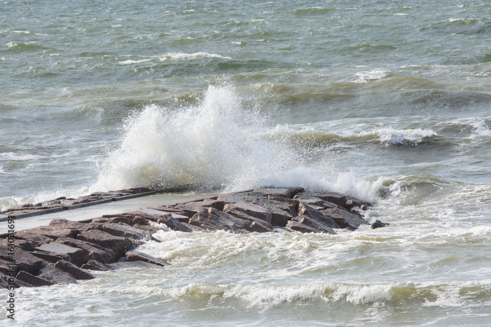 Obraz premium Rough surf breaking over jetty