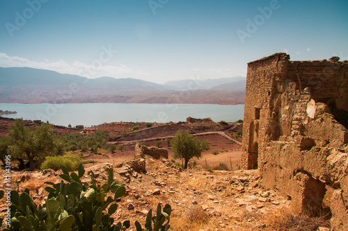 ruin of a kasbah with view of lake against sky in a sunny day - bine el ouidane - morocco