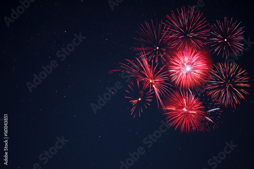 Red  fireworks located right side over night sky