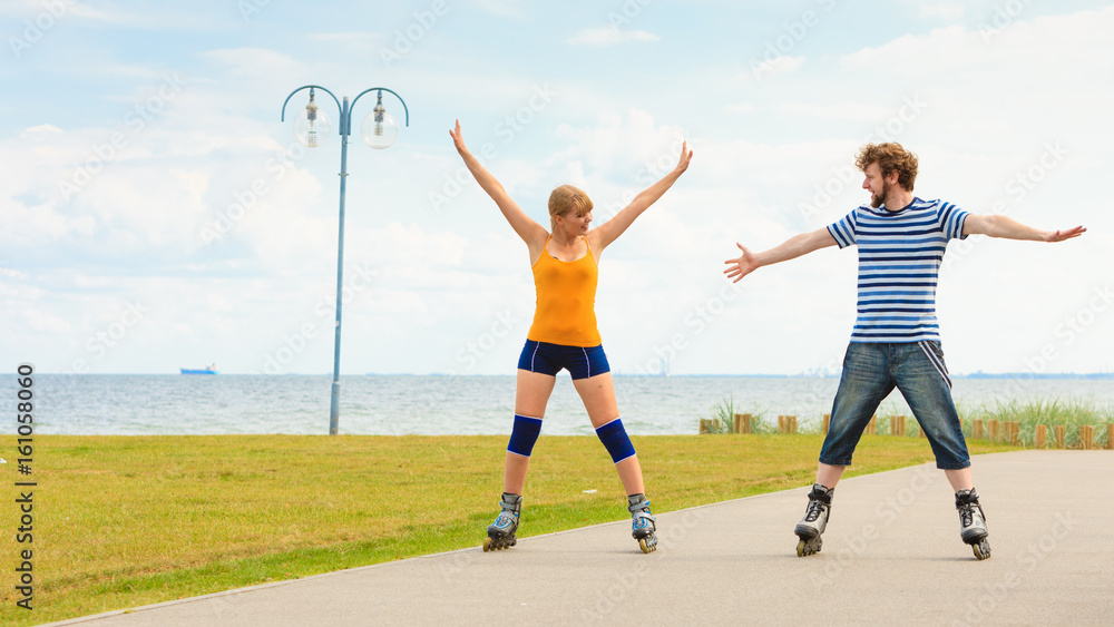 Obraz premium Young couple on roller skates riding outdoors