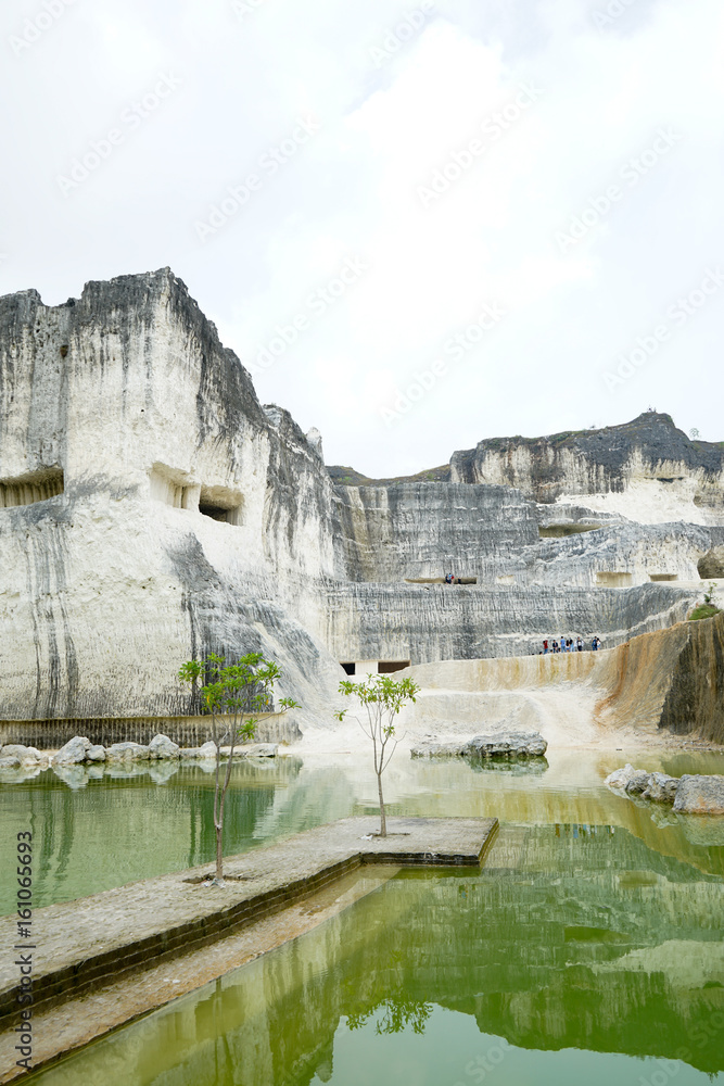 Blue or green natural mineral lake, beautiful view of the white chalk limestone hill in Jaddih or Jeddih Hill, Madura Island, Indonesia