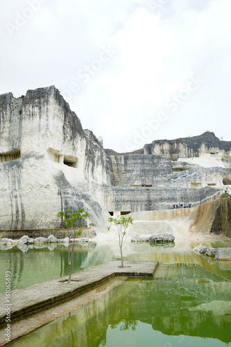 Blue or green natural mineral lake, beautiful view of the white chalk limestone hill in Jaddih or Jeddih Hill, Madura Island, Indonesia