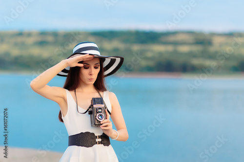 Summer Tourist Girl with Retro Camera and Big Straw Hat © nicoletaionescu