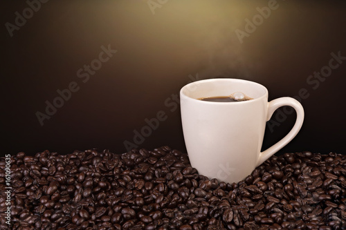 A cup of coffee and coffee beans on isolated background