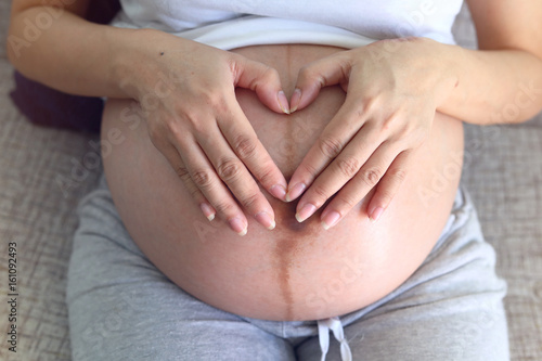 Wallpaper Mural beautiful woman pregnant hand heart signals for baby love Torontodigital.ca