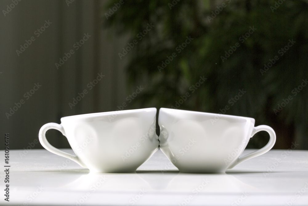 Two white cups on a gray background. I love uou. Two white cups on a gray background. I love uou.