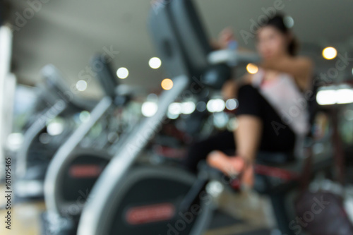 blurred woman cycling burn fat on bicycle cardio machine in fitness gym