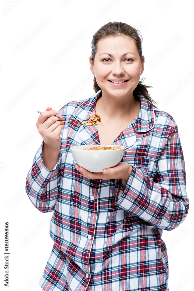 Cheerful beautiful brunette in pajamas eating breakfast cereal with milk on white background Cheerful beautiful brunette in pajamas eating breakfast cereal with milk on white background