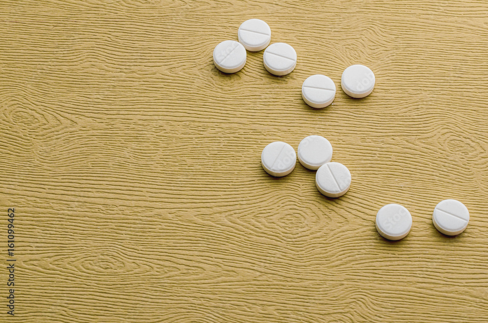 Several white tablets on a wooden table Several white tablets on a wooden table