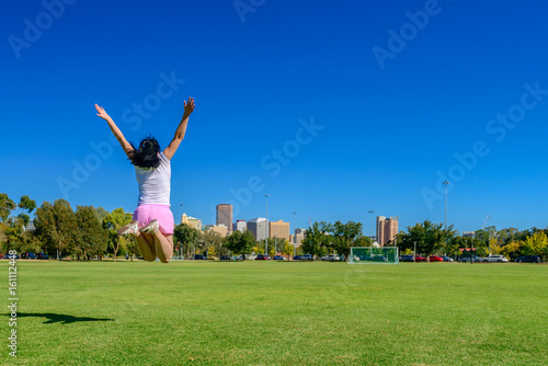 Happy woman jumping up in Adelaide city