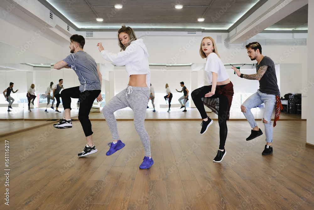 Group of young modern dancers dancing in the studio. Sport, dancing and urban culture concept Group of young modern dancers dancing in the studio. Sport, dancing and urban culture concept