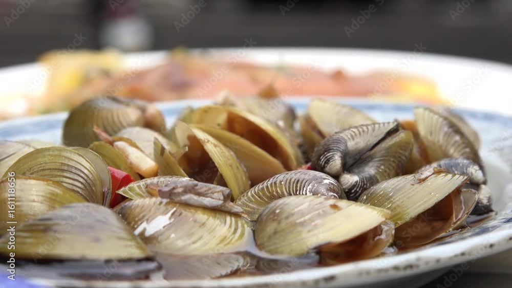 Dish with clams in an open air restaurant at the Ci Sheng Temple in Taipei, Taiwan. 4K. Dish with clams in an open air restaurant at the Ci Sheng Temple in Taipei, Taiwan. 4K.