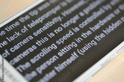 Teleprompter automatically scrolls text close-up. photo