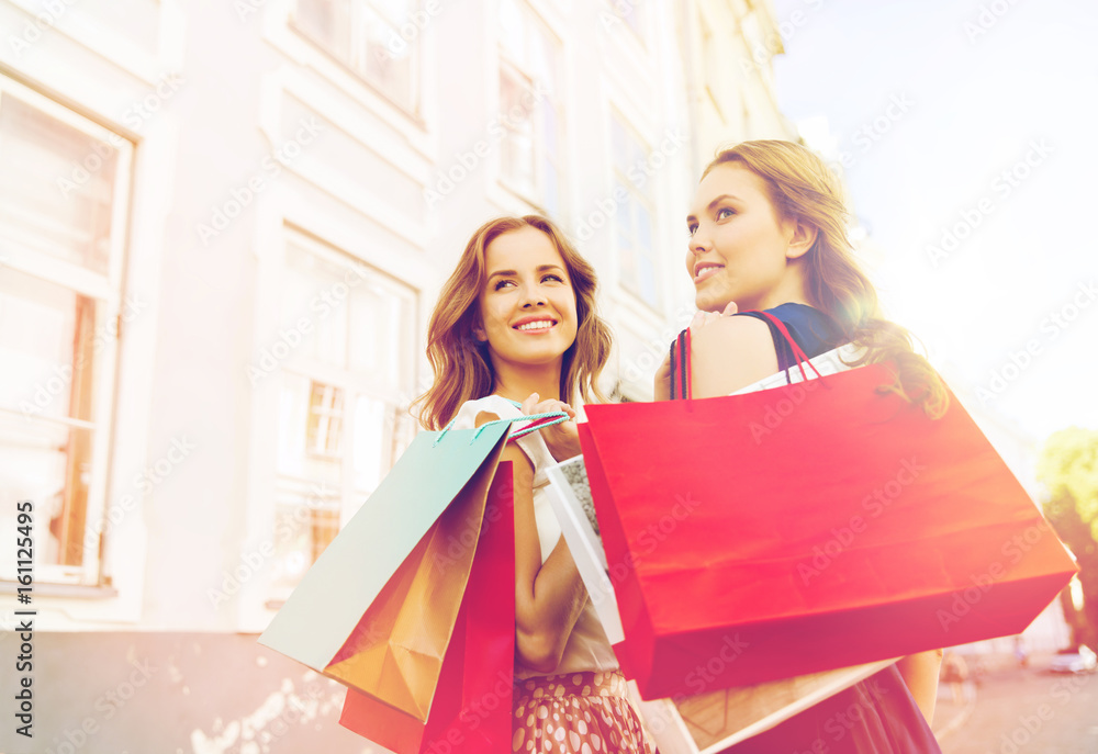 happy women with shopping bags walking in city happy women with shopping bags walking in city
