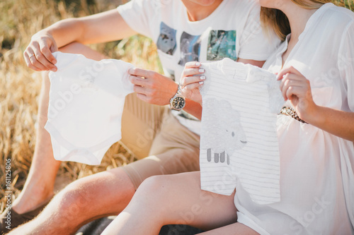 Young beautiful pregnant woman having picnic with her husband