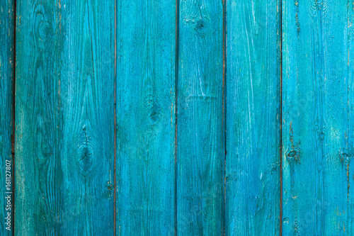 Vintage wooden texture of an old fence painted blue. Vertical texture on background
