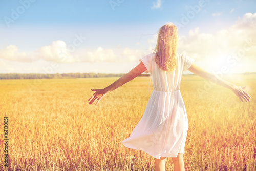 happy young woman in white dress on cereal field