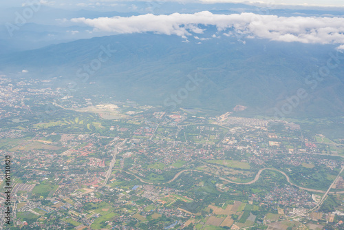 A cityscape with a mountain on the side view from the airplane window.