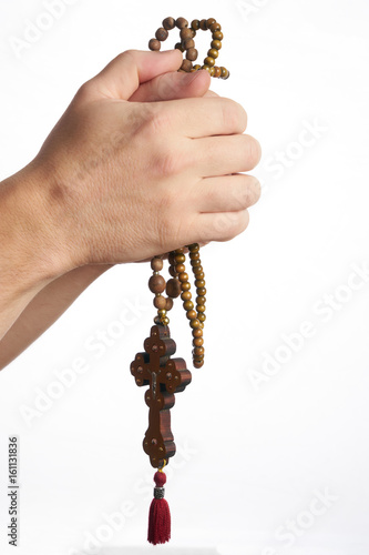 Praying Christian or Catholic man hands with a wooden rosary isolated on white background. Religion concept.