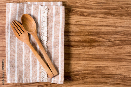 Wooden spoon and fork  on fabric with wooden table.