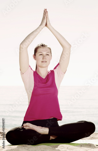 Girl practicing yoga poses on beach © JackF