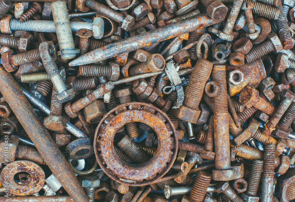 Old rusty worn metal details- bolts nuts bearings chain lie in a heap. Old rusty worn metal details- bolts nuts bearings chain lie in a heap.