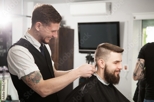 Professional barber doing a haircut © George Dolgikh