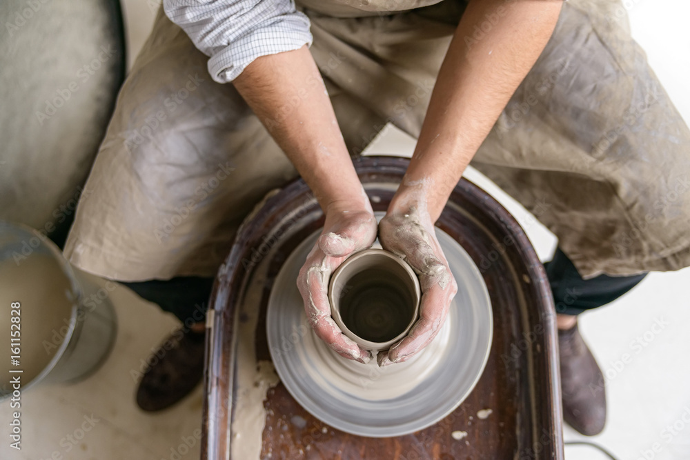 Fototapeta premium Hands working on pottery wheel