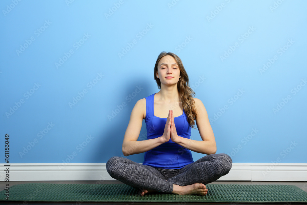 Meditating girl with praying hands sitting lotus with closed eyes indoor Meditating girl with praying hands sitting lotus with closed eyes indoor