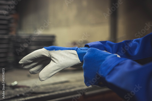 Worker getting on a pair of protection gloves.