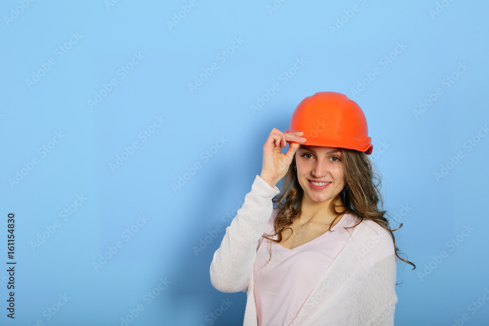 Happy easy repair with smiling woman in orange helmet on blue background, looking camera, copy space