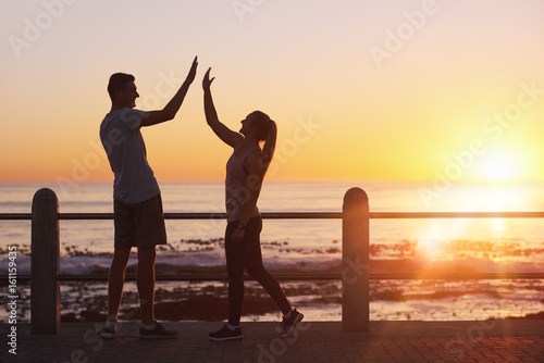 Sporty couple high five at end of run workout