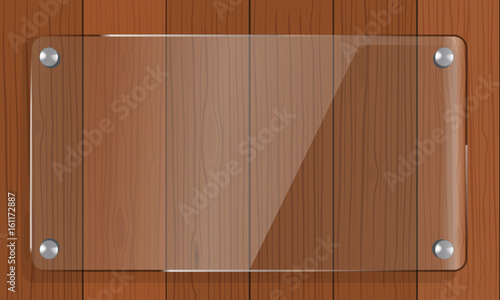 Transparent glass empty plate mock up with brown wooden background.