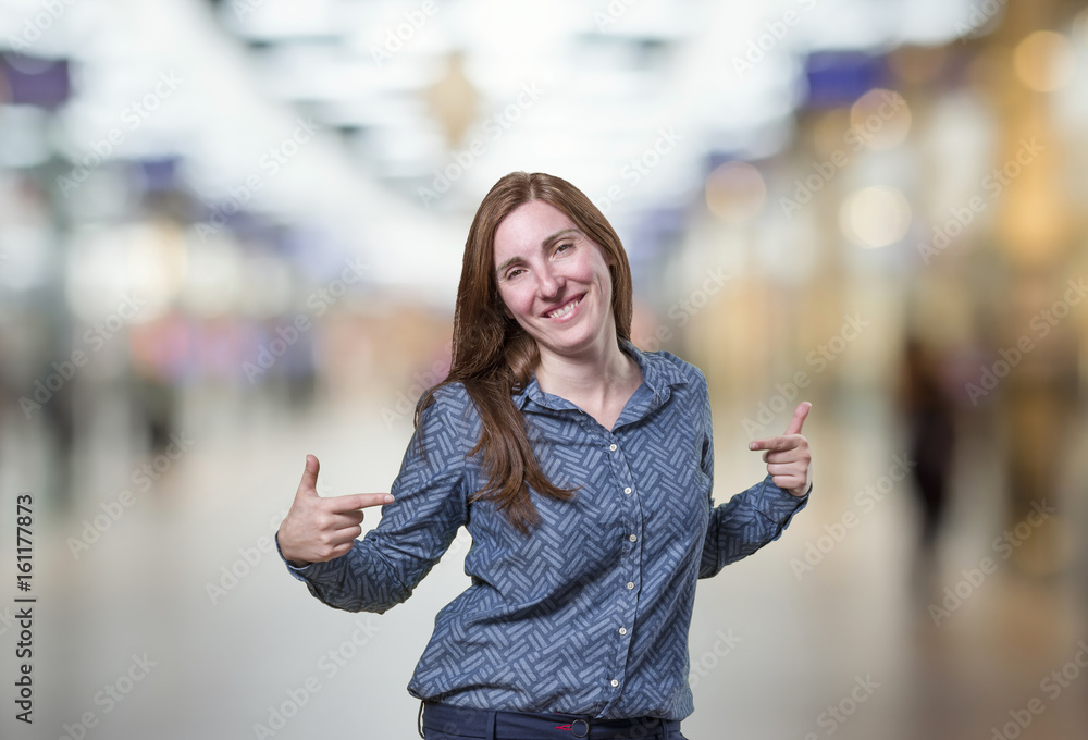 Pretty business woman pointing herself over blur background