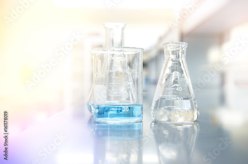 blue solution in beaker and flask with science laboratory