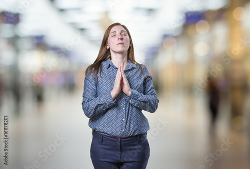 Pretty business woman doing meditation over blur background